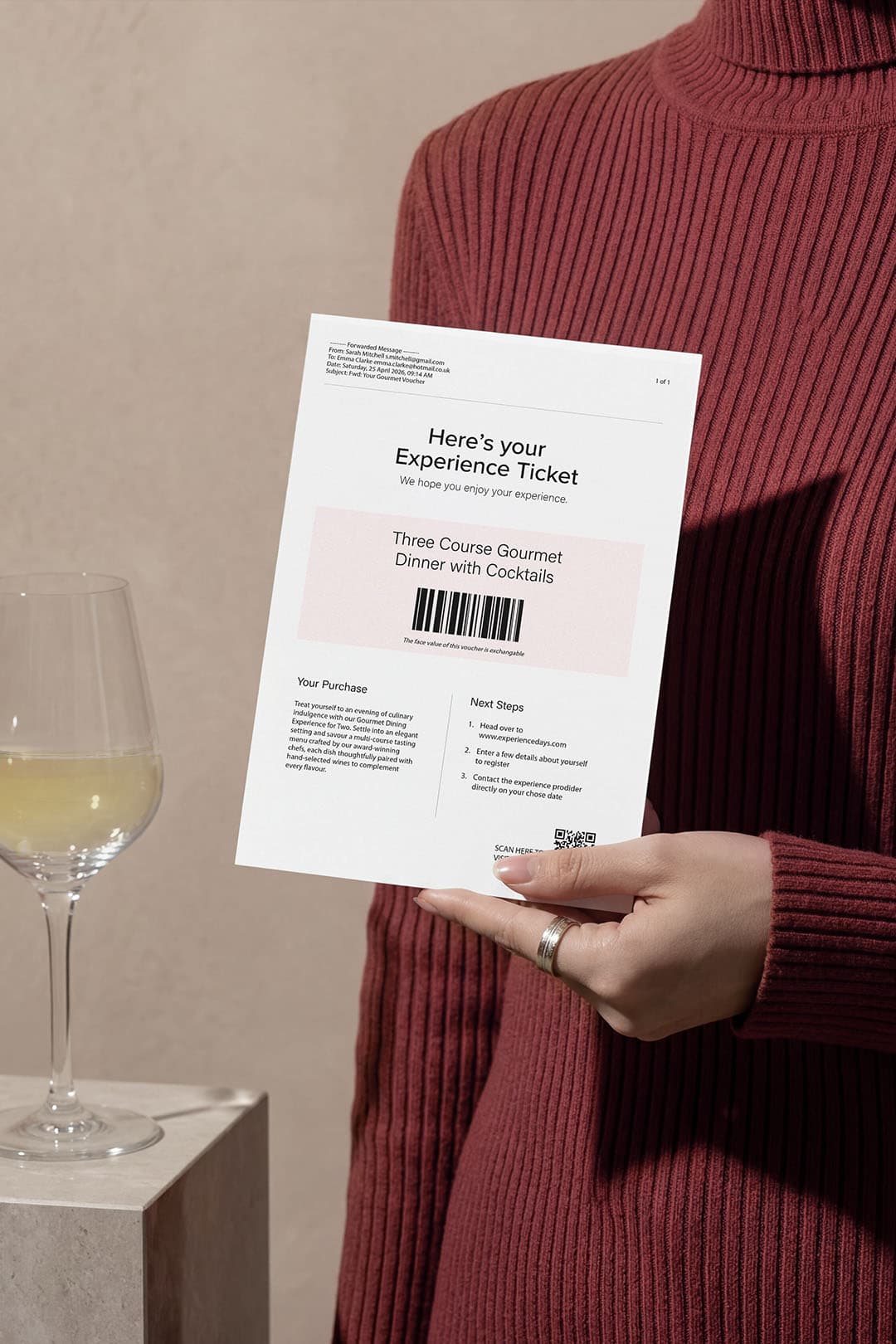 A plain printed experience voucher held in hand for a three course gourmet dinner.