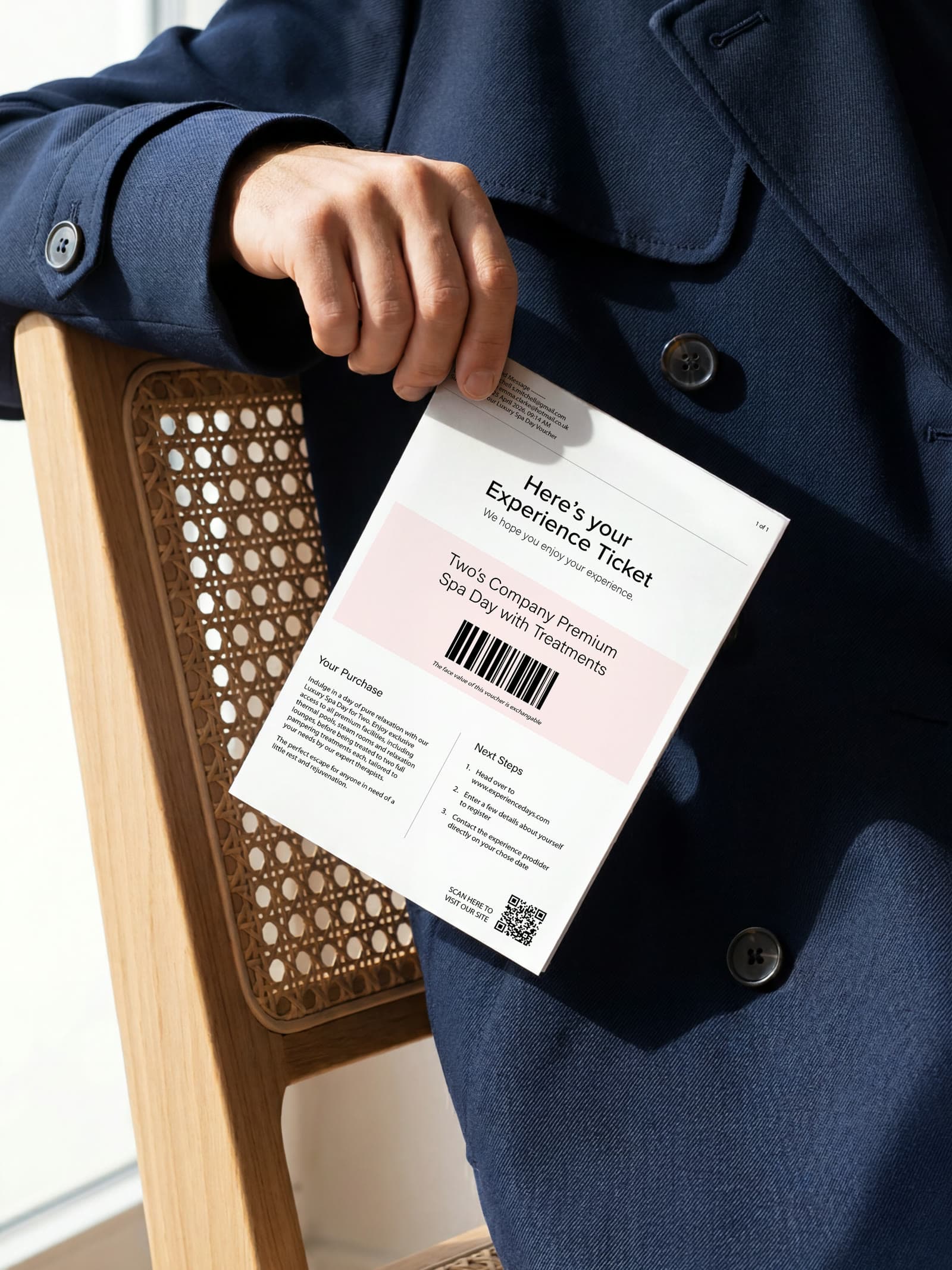 A plain printed experience voucher for a classic car drive, held in hand.